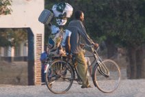 10: On bycicle carring baby and bagages